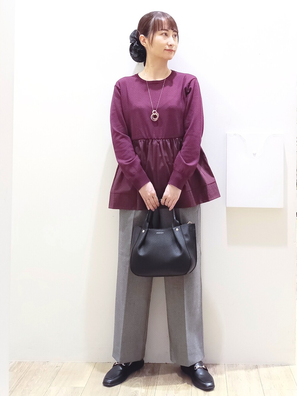 レッド系のニット/セーター、ブラック系のその他パンツ、ブラック系のトートバッグを着用したレディースの秋コーディネートの3枚目の写真