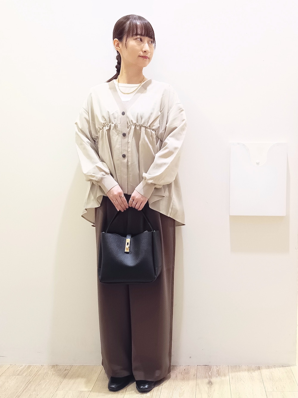 ホワイト系のTシャツ/カットソー、ベージュ系のカーディガン/ボレロ、ブラウン系のその他パンツを着用したレディースの秋コーディネートの3枚目の写真