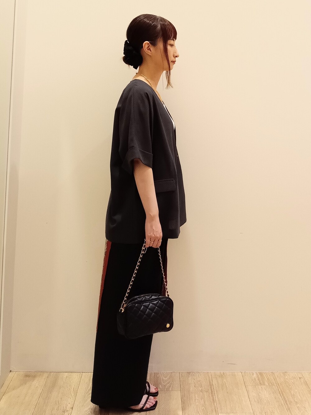 グレー系のノーカラージャケット、ホワイト系のタンクトップ、ブラック系のその他パンツを着用したレディースの夏コーディネートの3枚目の写真