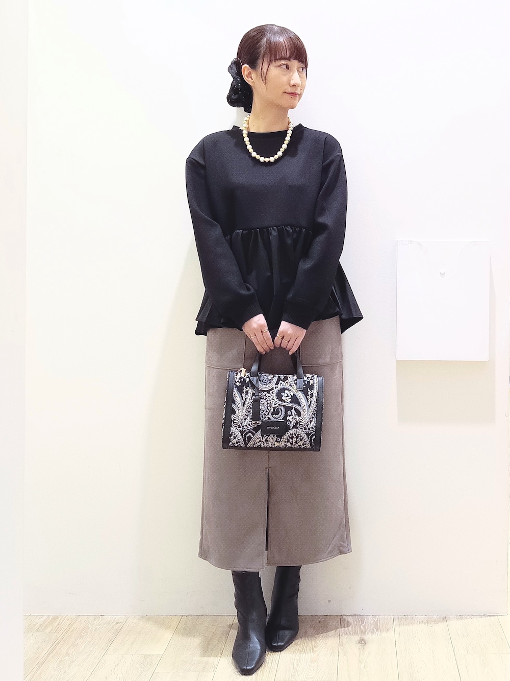 ブラック系のTシャツ/カットソー、ブラウン系のスカート、ブラック系のトートバッグを着用したレディースの秋コーディネートの2枚目の写真