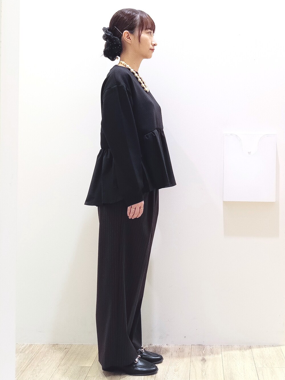 ブラック系のTシャツ/カットソー、ブラウン系のその他パンツ、イエロー系のトートバッグを着用したレディースの秋コーディネートの3枚目の写真
