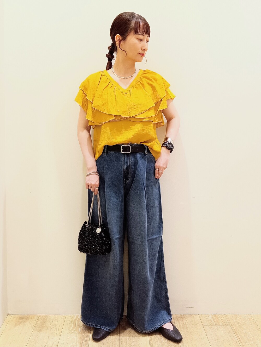 イエロー系のシャツ/ブラウス、ブルー系のデニムパンツ、ブラック系のショルダーバッグを着用したレディースの夏コーディネートの2枚目の写真