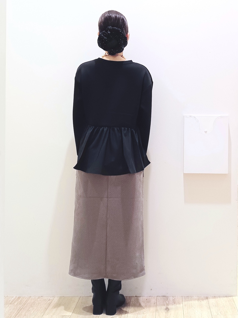 ブラック系のTシャツ/カットソー、ブラウン系のスカート、ブラック系のトートバッグを着用したレディースの秋コーディネートの5枚目の写真