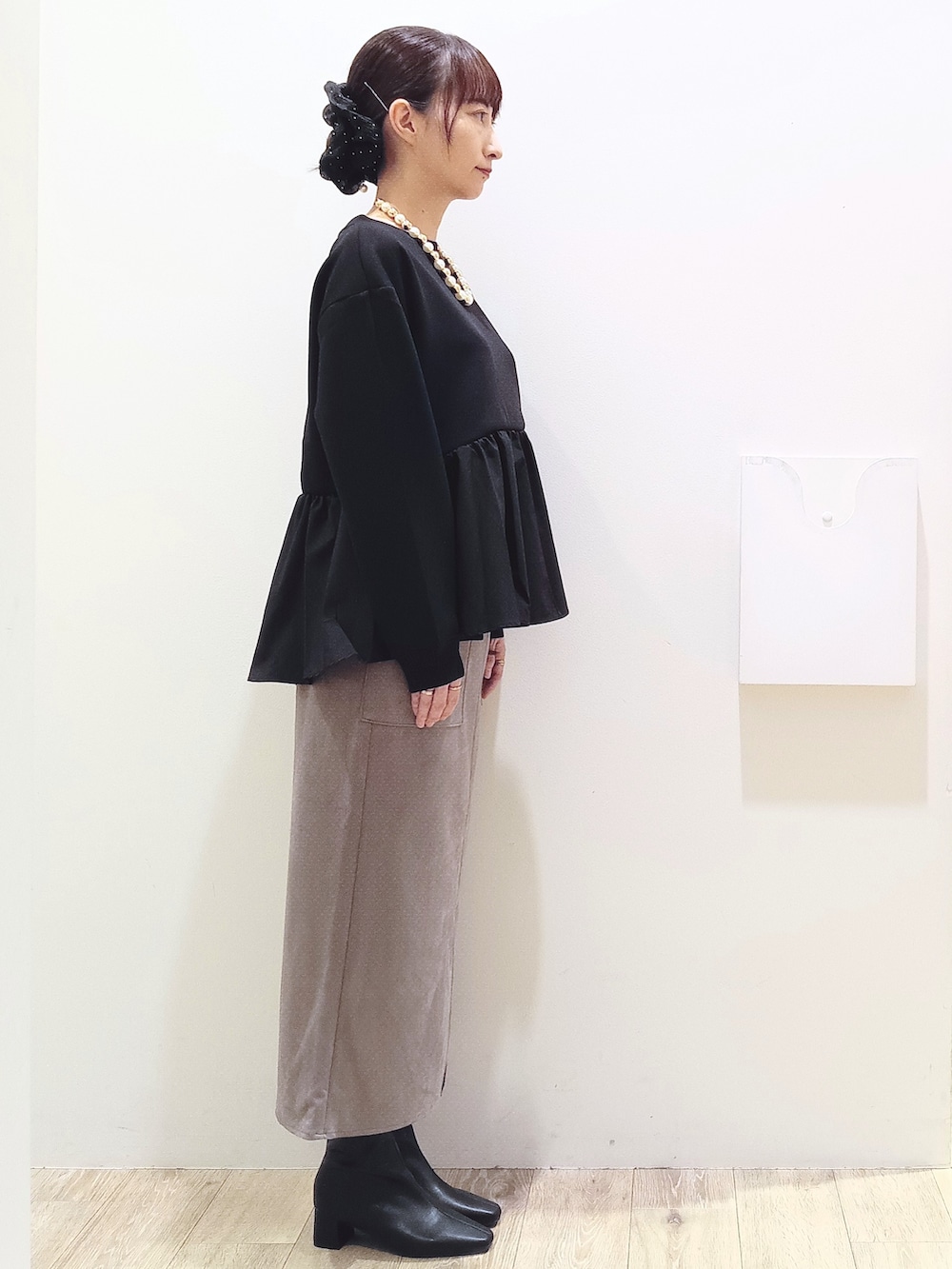 ブラック系のTシャツ/カットソー、ブラウン系のスカート、ブラック系のトートバッグを着用したレディースの秋コーディネートの3枚目の写真