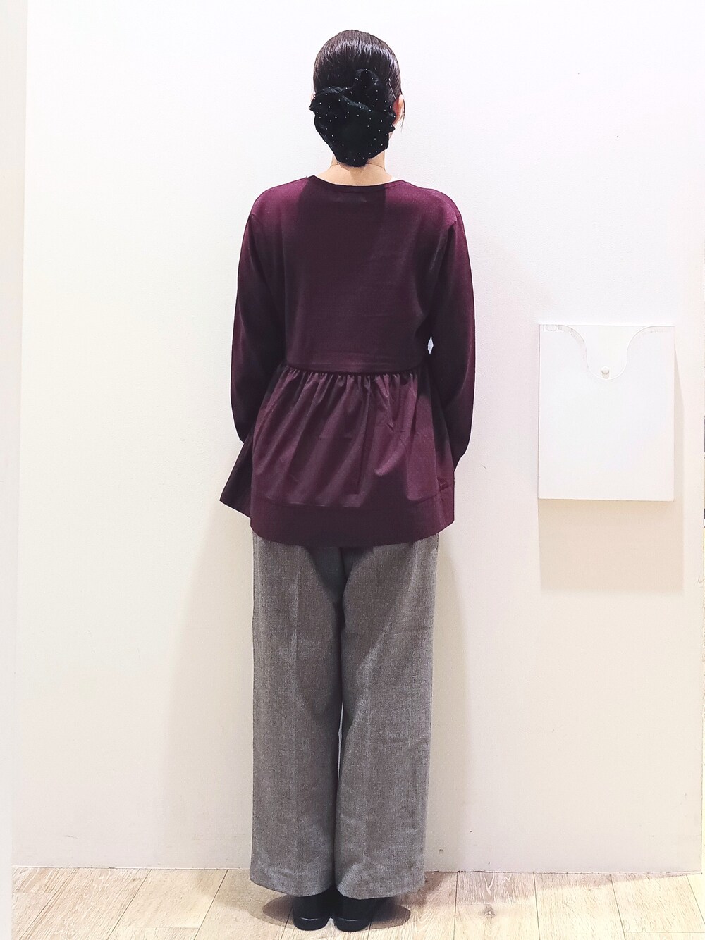 レッド系のニット/セーター、ブラック系のその他パンツ、ブラック系のトートバッグを着用したレディースの秋コーディネートの6枚目の写真