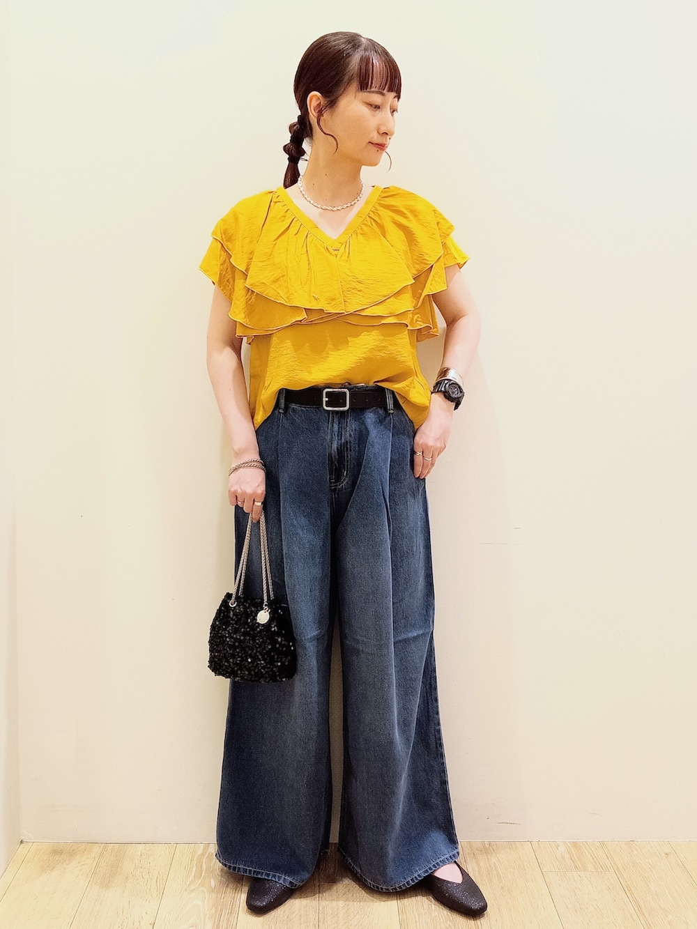 イエロー系のシャツ/ブラウス、ブルー系のデニムパンツ、ブラック系のショルダーバッグを着用したレディースの夏コーディネートの2枚目の写真
