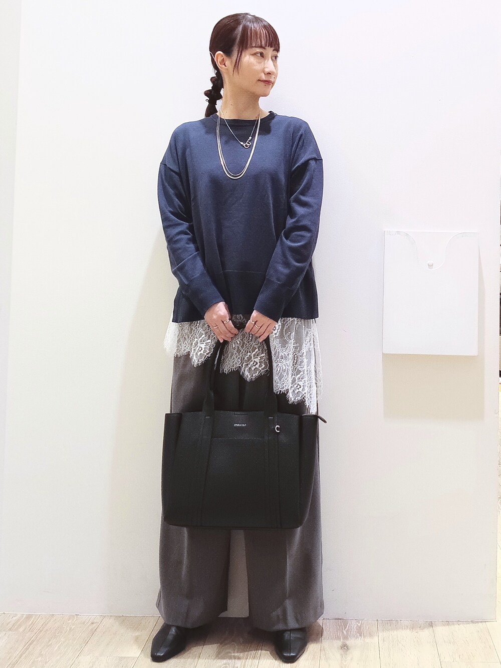 ブルー系のニット/セーター、ホワイト系のTシャツ/カットソー、グレー系のその他パンツを着用したレディースの秋コーディネートの3枚目の写真