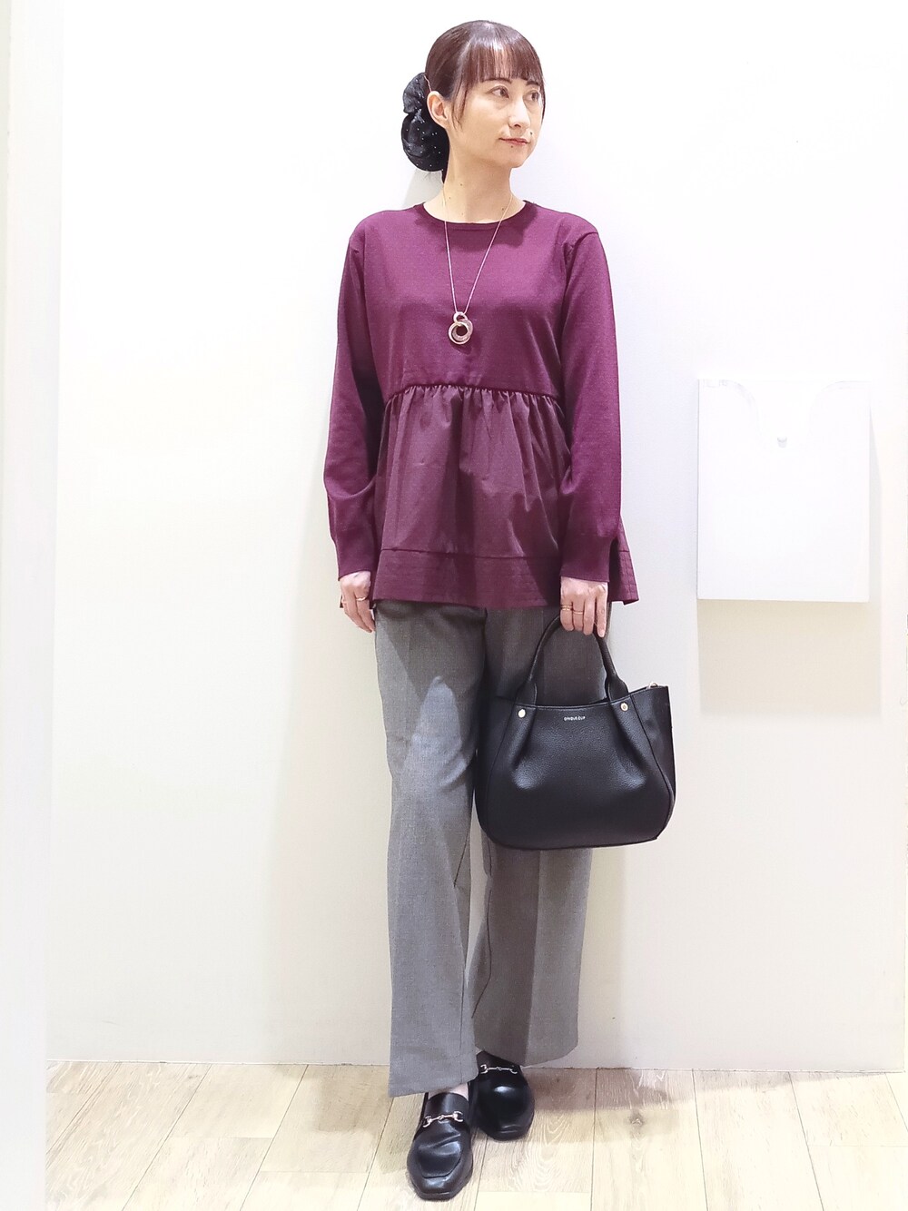 レッド系のニット/セーター、ブラック系のその他パンツ、ブラック系のトートバッグを着用したレディースの秋コーディネートの2枚目の写真