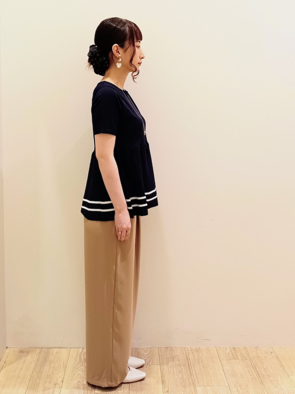 ブルー系のニット/セーター、ベージュ系のその他パンツ、ホワイト系のショルダーバッグを着用したレディースの夏コーディネートの4枚目の写真