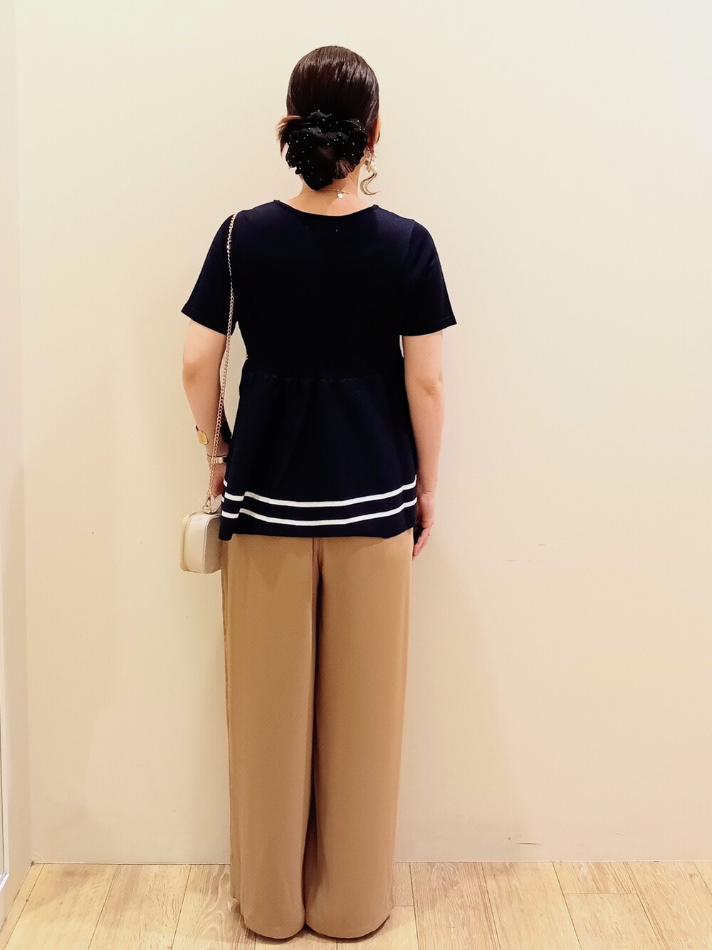 ブルー系のニット/セーター、ベージュ系のその他パンツ、ホワイト系のショルダーバッグを着用したレディースの夏コーディネートの5枚目の写真