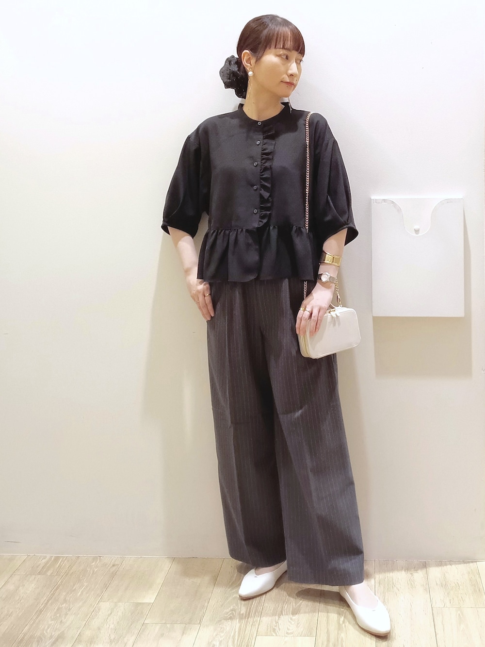 ブラック系のシャツ/ブラウス、グレー系のその他パンツ、ホワイト系のショルダーバッグを着用したレディースの秋コーディネートの2枚目の写真