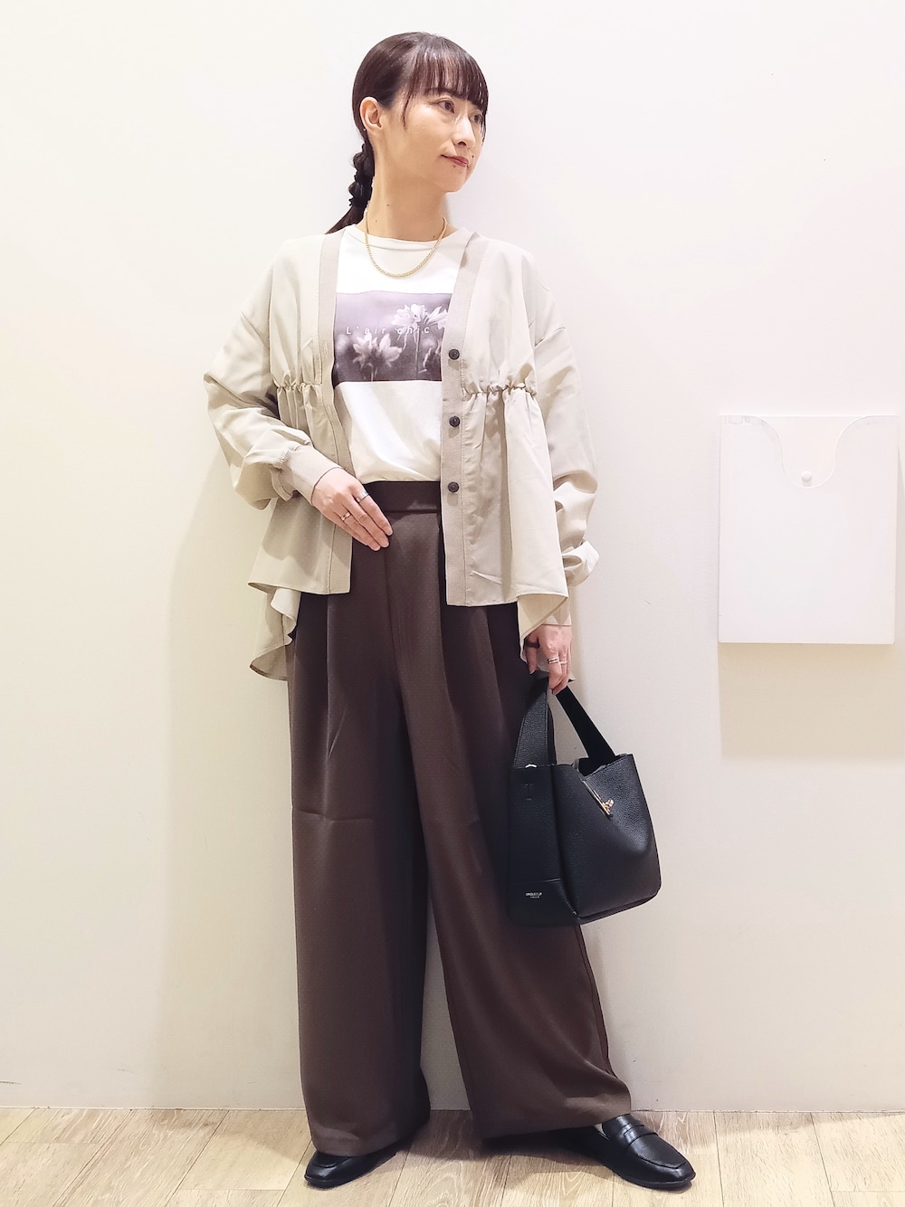 ホワイト系のTシャツ/カットソー、ベージュ系のカーディガン/ボレロ、ブラウン系のその他パンツを着用したレディースの秋コーディネートの2枚目の写真