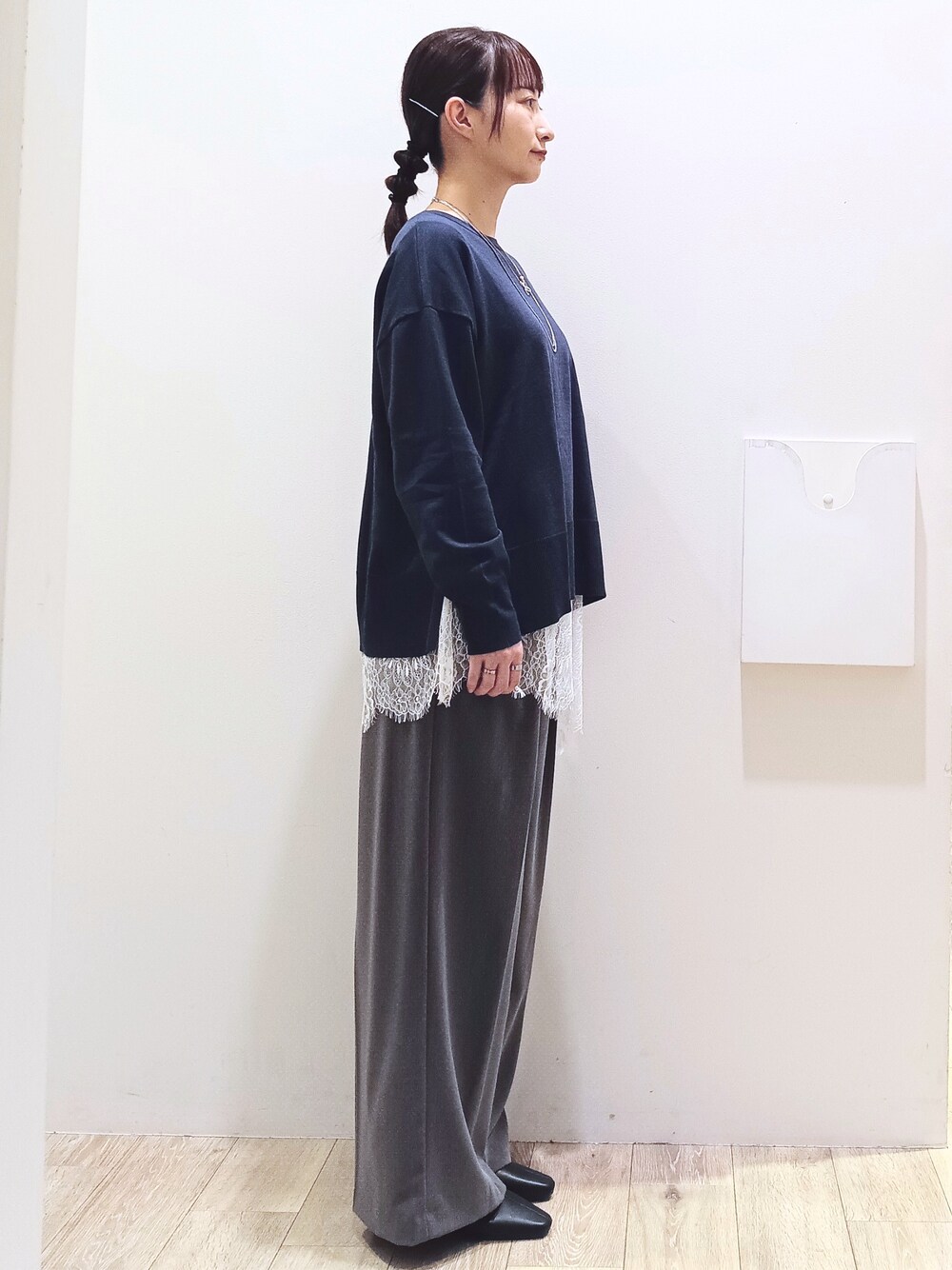 ブルー系のニット/セーター、ホワイト系のTシャツ/カットソー、グレー系のその他パンツを着用したレディースの秋コーディネートの4枚目の写真
