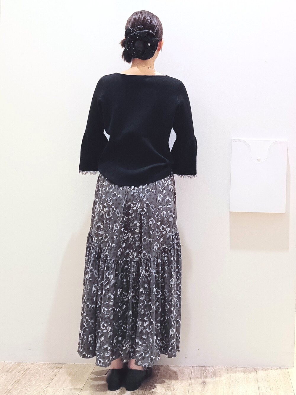 ブラック系のニット/セーター、グレー系のスカート、ホワイト系のハンドバッグを着用したレディースの秋コーディネートの6枚目の写真