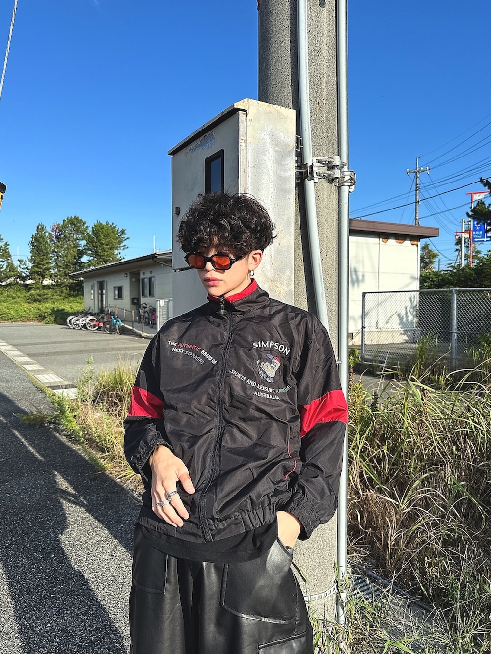 ブラック系のカーゴパンツ、ブラック系のスニーカー、ブラック系のナイロンジャケットを着用したメンズの秋コーディネートの2枚目の写真