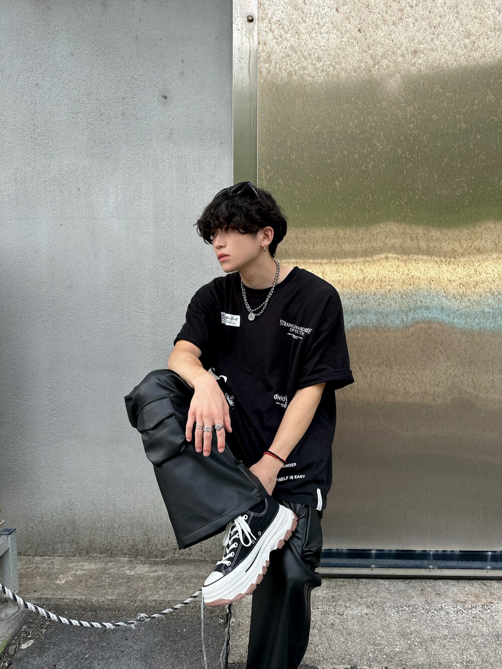 ブラック系のTシャツ/カットソー、ブラック系のカーゴパンツ、ブラック系のスニーカーを着用したメンズの夏コーディネートの3枚目の写真