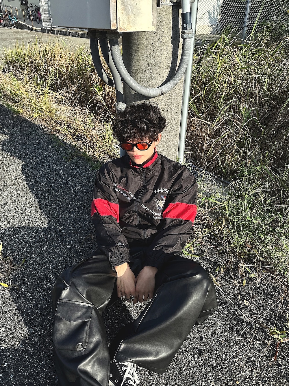 ブラック系のカーゴパンツ、ブラック系のスニーカー、ブラック系のナイロンジャケットを着用したメンズの秋コーディネートの3枚目の写真