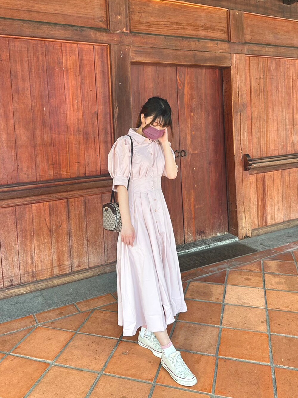 ピンク系のワンピース、ホワイト系のスニーカー、ブラウン系のショルダーバッグを着用したレディースの夏コーディネートの2枚目の写真