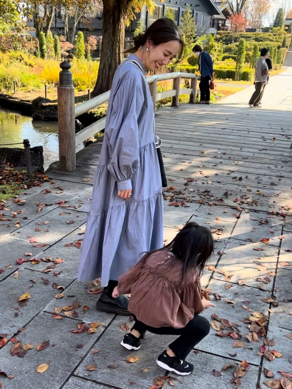 ブルー系のワンピースを着用したレディースの春コーディネートの2枚目の写真