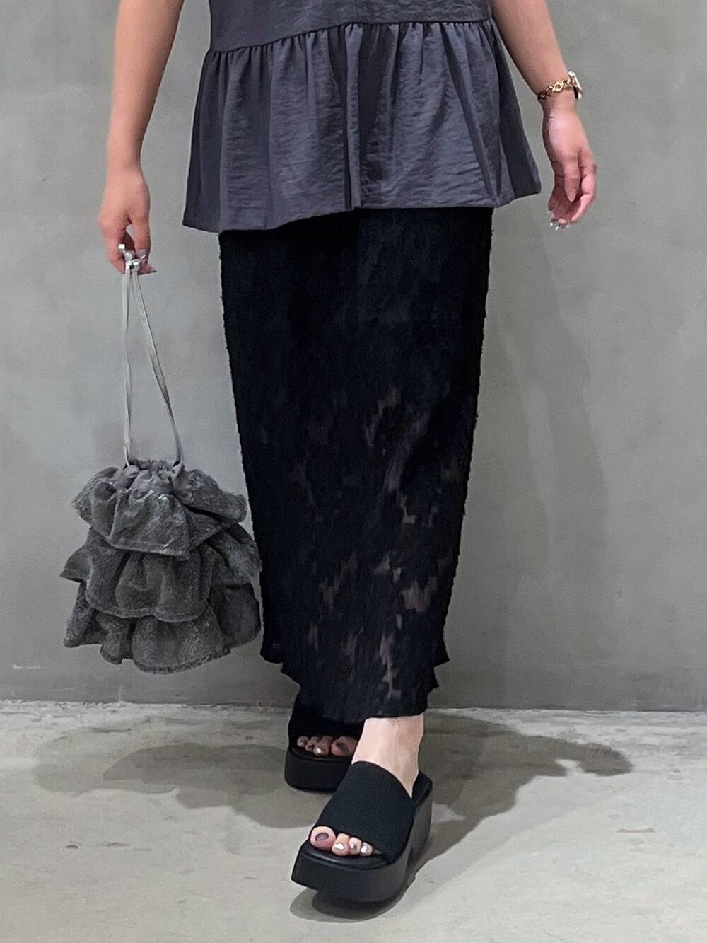 シルバー系のショルダーバッグ、ブラック系のサンダル、ブラック系のスカートを着用したレディースの夏コーディネートの6枚目の写真