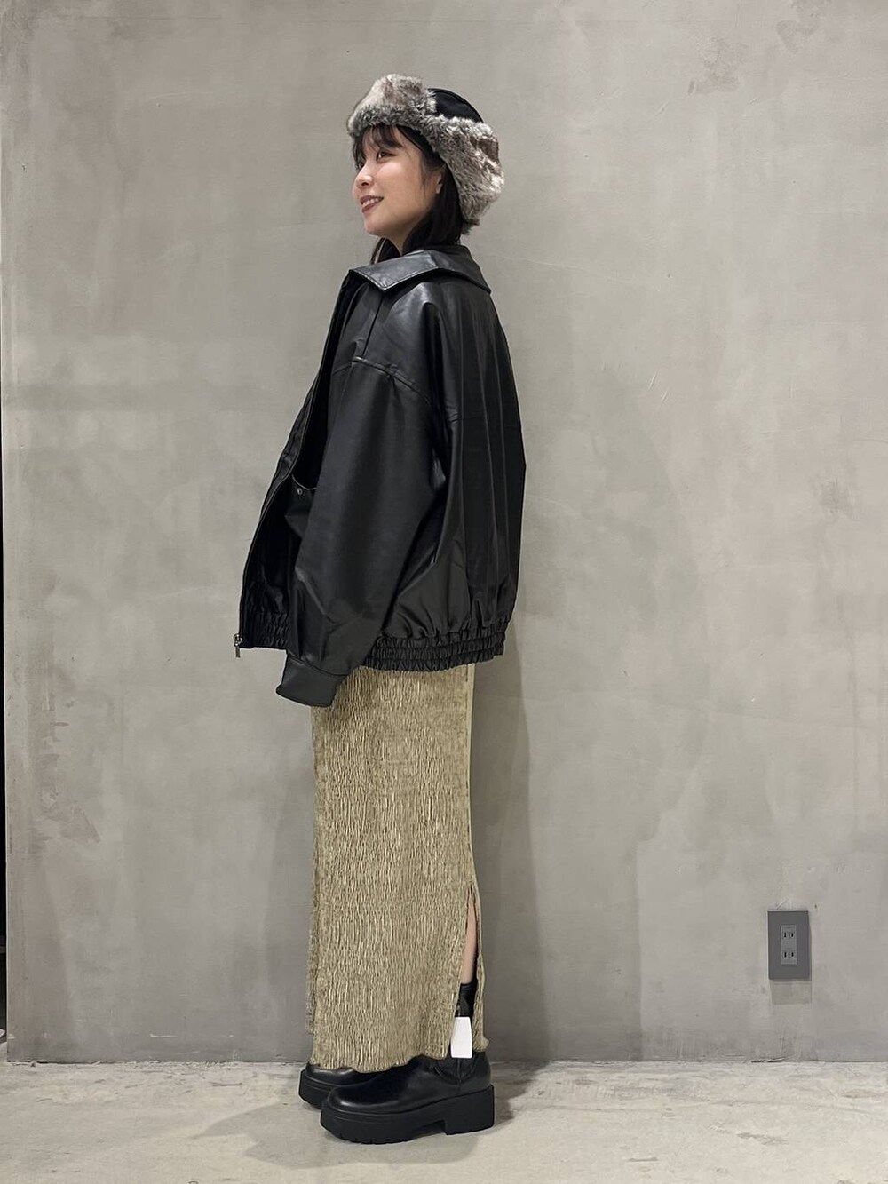 ブラック系のブルゾン、ブラック系のブーツ、ブラック系のニット/セーターを着用したレディースの秋コーディネートの2枚目の写真