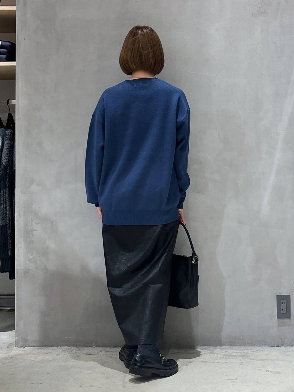 ブラック系のスカート、ブラック系のショルダーバッグ、ブルー系のニット/セーターを着用したレディースの冬コーディネートの3枚目の写真