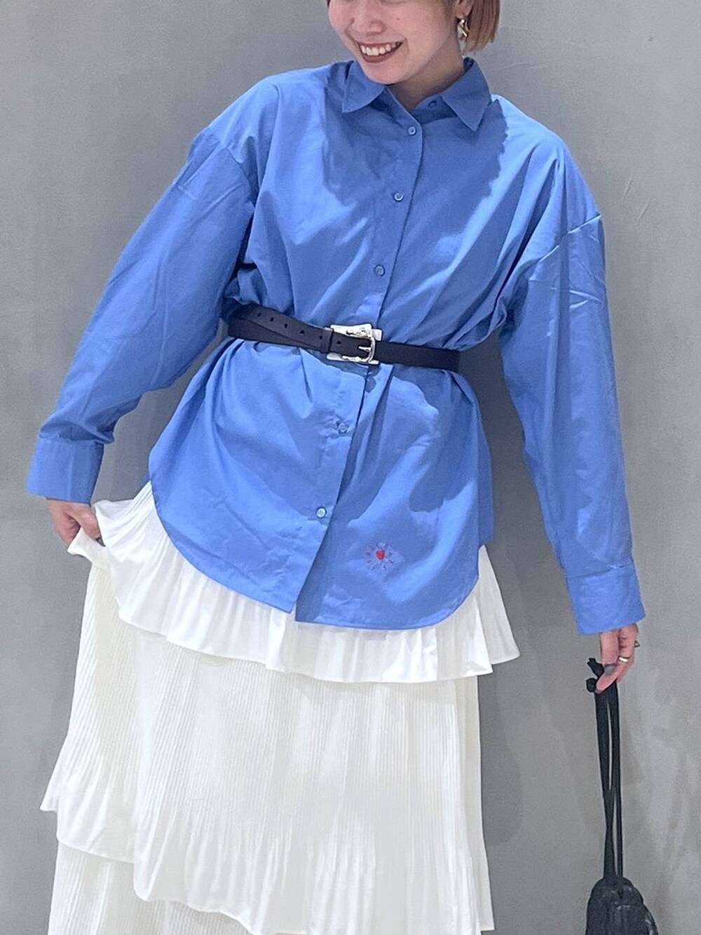 ベージュ系のスカート、ブラック系のショルダーバッグ、ブルー系のシャツ/ブラウスを着用したレディースの秋コーディネートの4枚目の写真