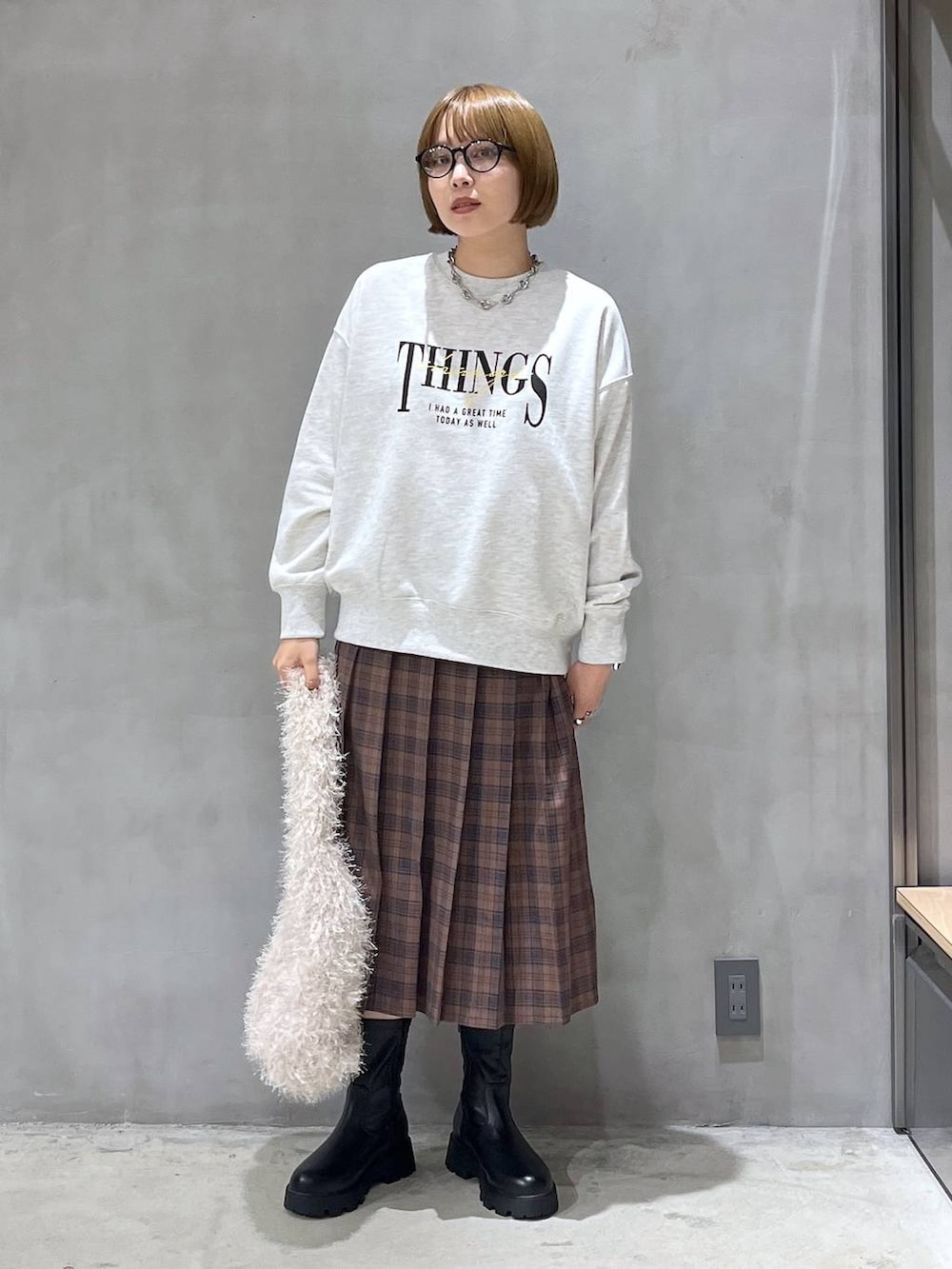 ブラック系のブーツ、ベージュ系のショルダーバッグ、ベージュ系のスウェットを着用したレディースの秋コーディネートの2枚目の写真