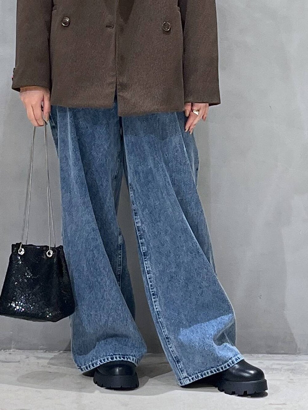 ブルー系のデニムパンツ、ブラック系のブーツ、ブラウン系のテーラードジャケットを着用したレディースの秋コーディネートの5枚目の写真