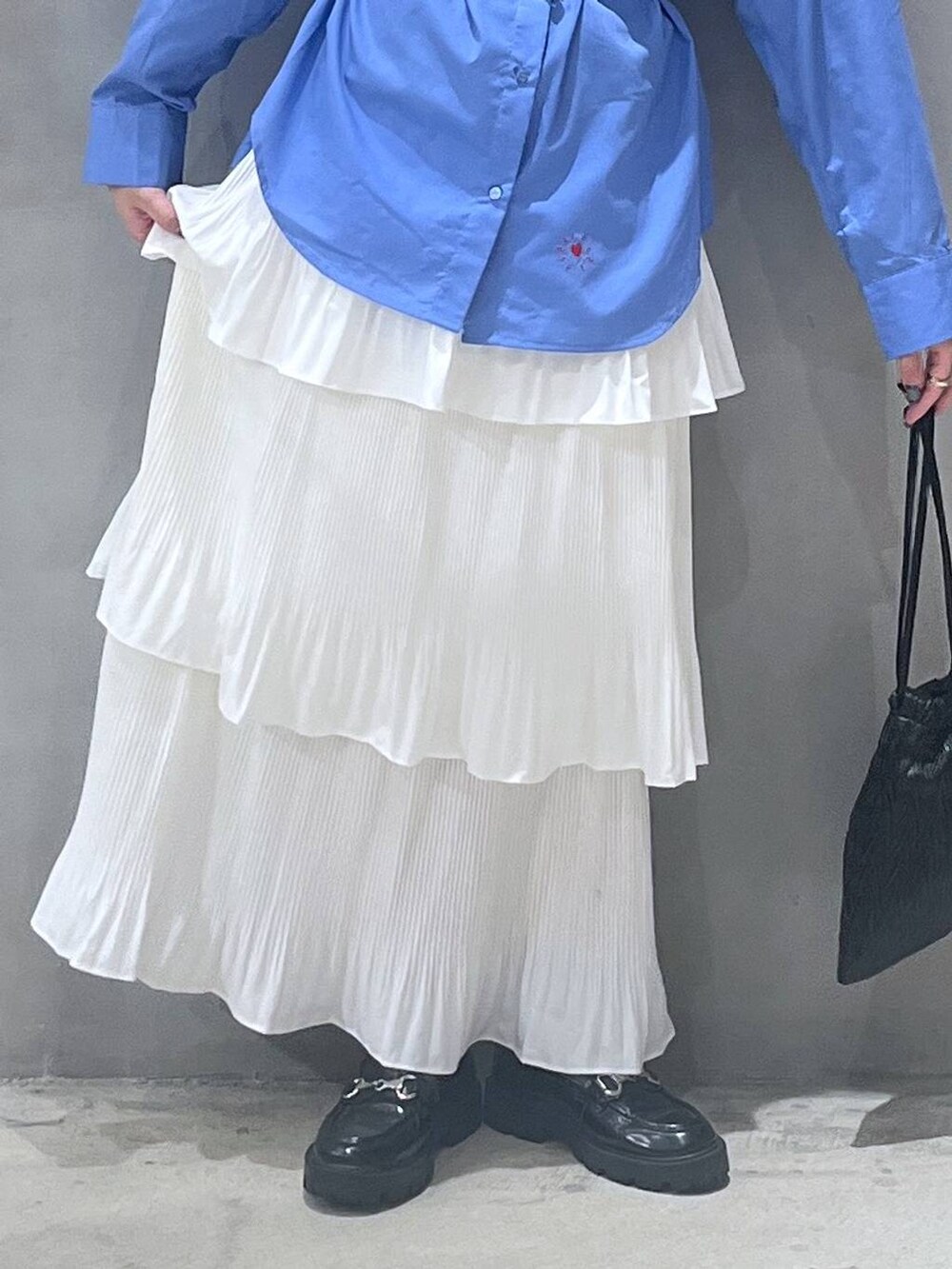 ベージュ系のスカート、ブラック系のショルダーバッグ、ブルー系のシャツ/ブラウスを着用したレディースの秋コーディネートの5枚目の写真