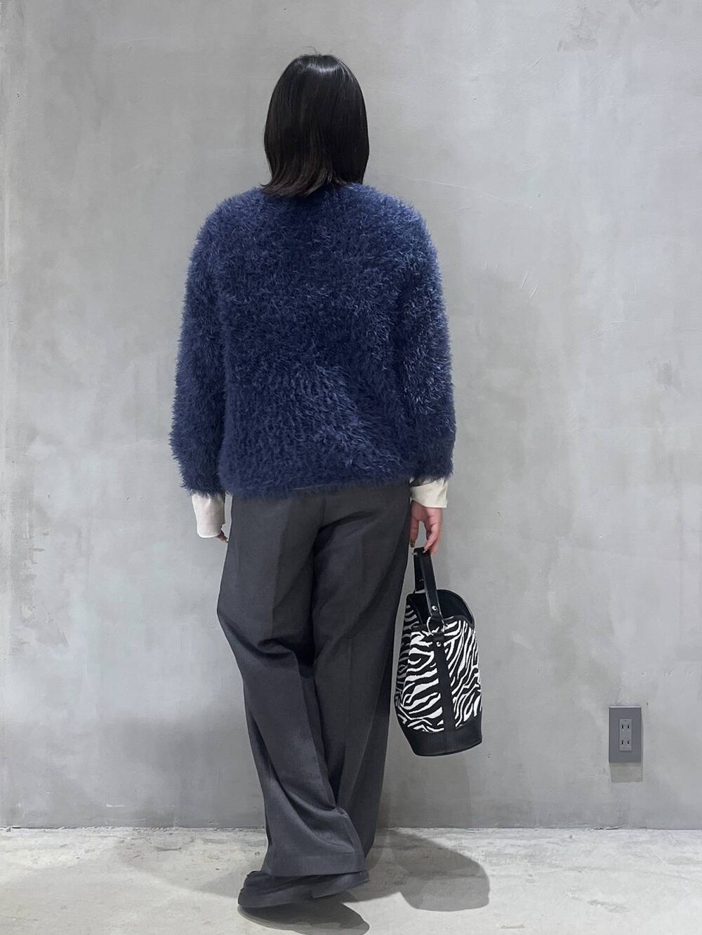 その他のショルダーバッグ、グレー系のスラックス、ブルー系のニット/セーターを着用したレディースの秋コーディネートの3枚目の写真