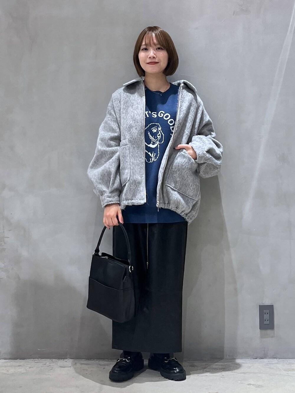 ブラック系のスカート、ブラック系のショルダーバッグ、ブルー系のニット/セーターを着用したレディースの冬コーディネートの5枚目の写真