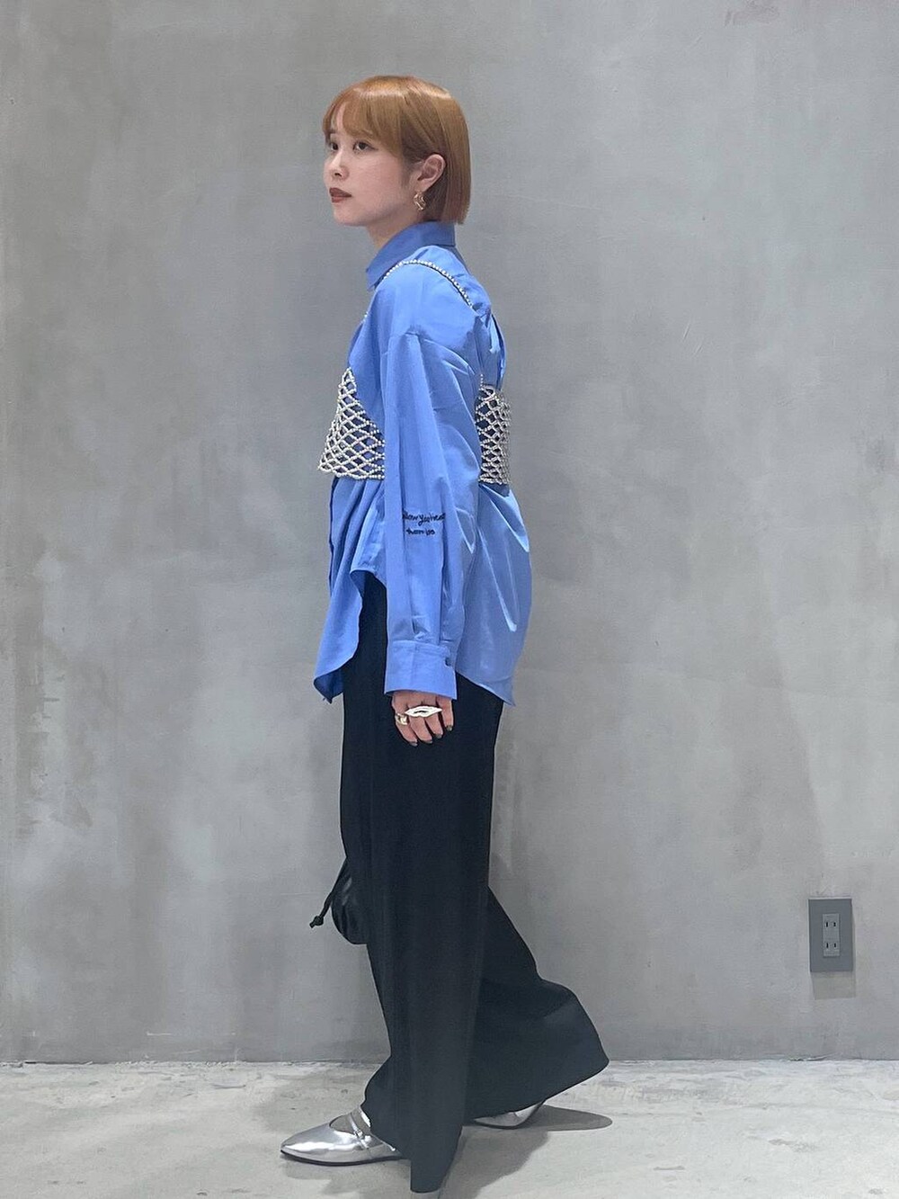 ブラック系のショルダーバッグ、シルバー系のパンプス、シルバー系のベストを着用したレディースの秋コーディネートの2枚目の写真