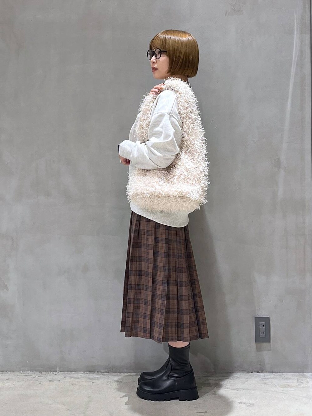 ブラック系のブーツ、ベージュ系のショルダーバッグ、ベージュ系のスウェットを着用したレディースの秋コーディネートの3枚目の写真