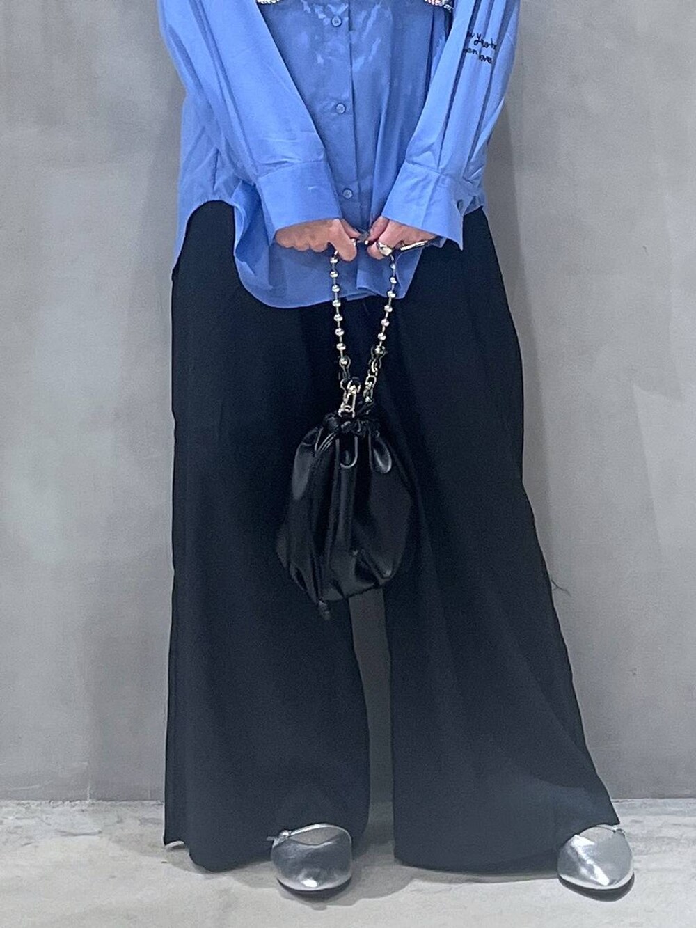 ブラック系のショルダーバッグ、シルバー系のパンプス、シルバー系のベストを着用したレディースの秋コーディネートの5枚目の写真