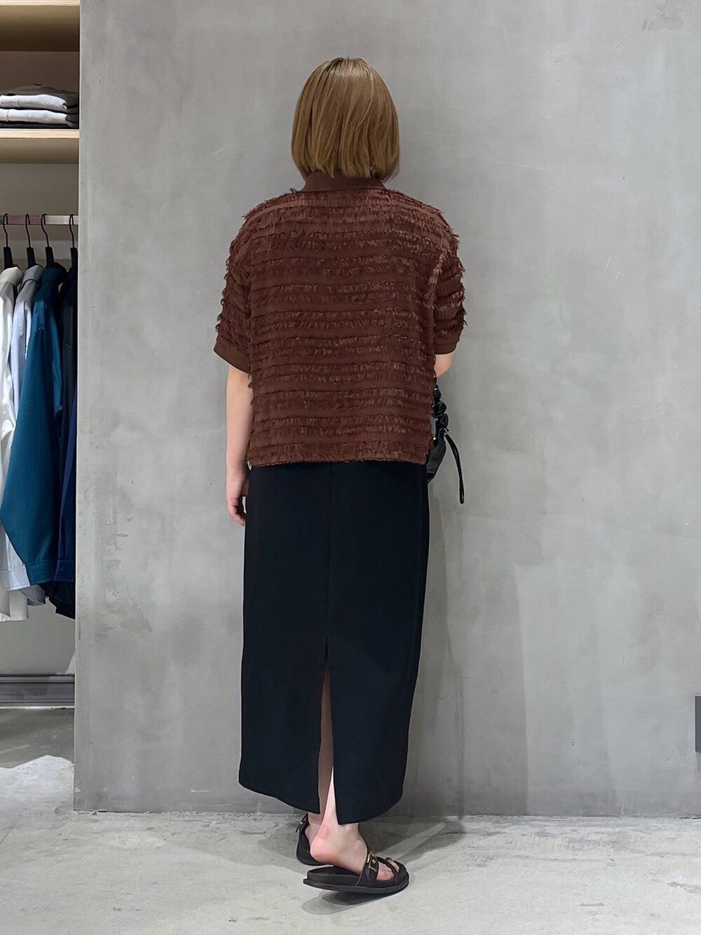 ブラック系のスカート、ブラック系のショルダーバッグ、ブラウン系のTシャツ/カットソーを着用したレディースの夏コーディネートの3枚目の写真