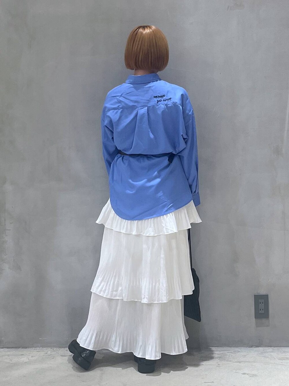 ベージュ系のスカート、ブラック系のショルダーバッグ、ブルー系のシャツ/ブラウスを着用したレディースの秋コーディネートの3枚目の写真