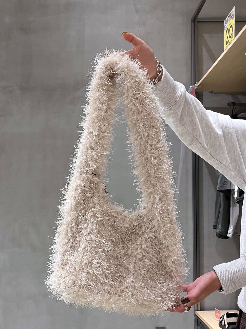 ブラック系のブーツ、ベージュ系のショルダーバッグ、ベージュ系のスウェットを着用したレディースの秋コーディネートの7枚目の写真