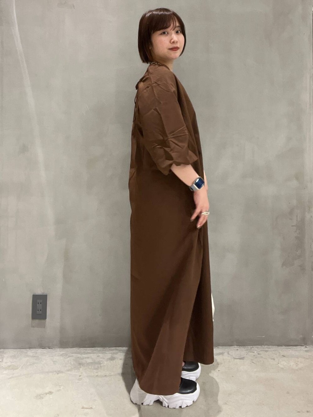 ブラック系のスニーカー、ベージュ系のショルダーバッグ、ブラウン系のワンピースを着用したレディースの夏コーディネートの2枚目の写真