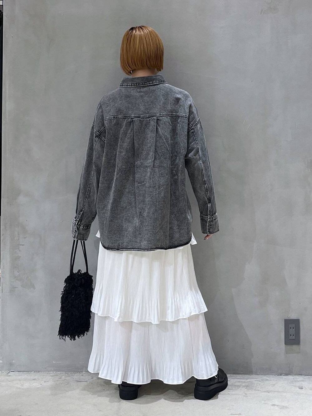 ベージュ系のスカート、ブラック系のショルダーバッグ、ブラック系のシャツ/ブラウスを着用したレディースの秋コーディネートの3枚目の写真