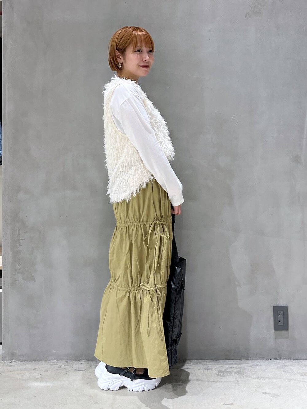 ブラック系のスニーカー、ブラック系のトートバッグ、ホワイト系のTシャツ/カットソーを着用したレディースの夏コーディネートの2枚目の写真