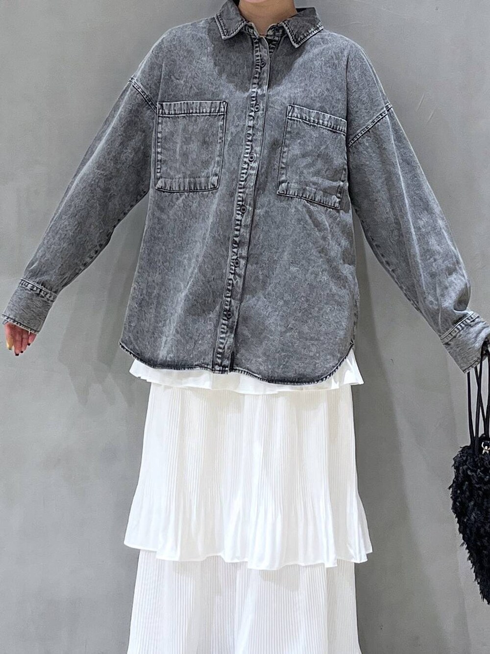 ベージュ系のスカート、ブラック系のショルダーバッグ、ブラック系のシャツ/ブラウスを着用したレディースの秋コーディネートの4枚目の写真