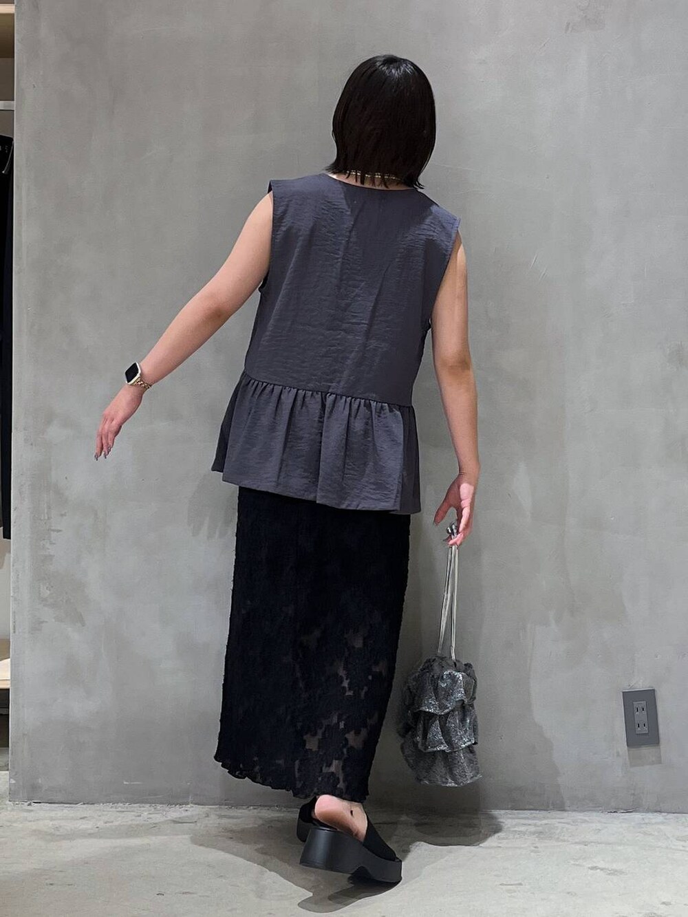 シルバー系のショルダーバッグ、ブラック系のサンダル、ブラック系のスカートを着用したレディースの夏コーディネートの4枚目の写真