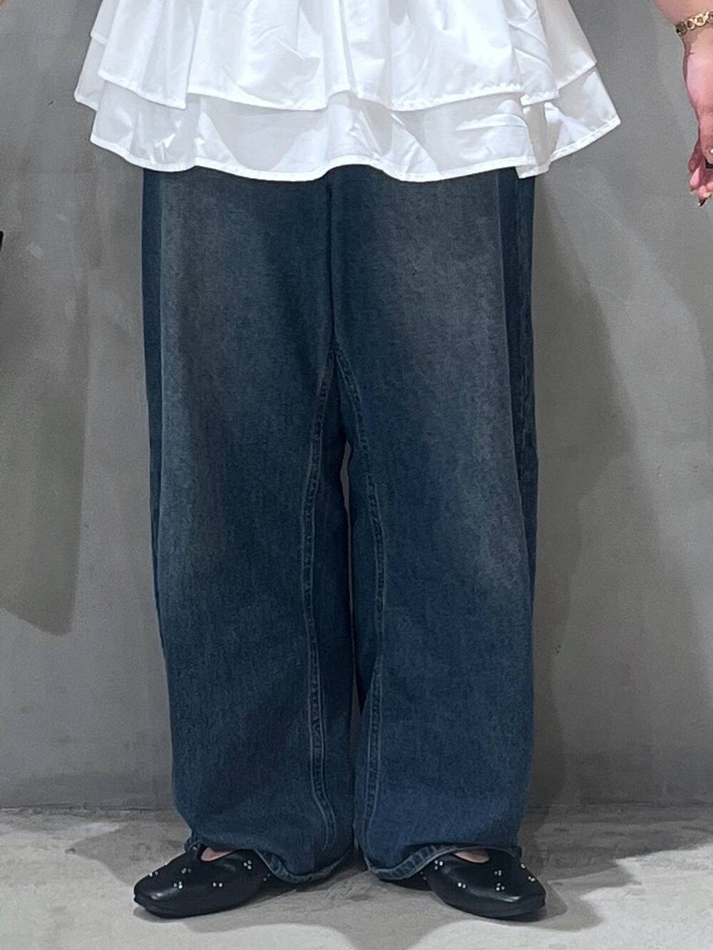 ブルー系のデニムパンツ、ブラック系のパンプス、ブラック系のショルダーバッグを着用したレディースの夏コーディネートの5枚目の写真