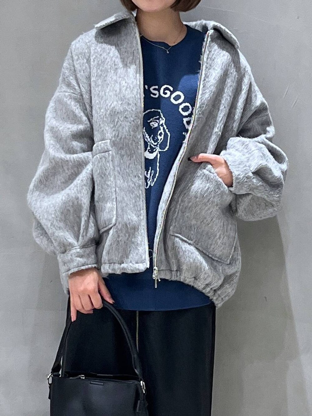 ブラック系のスカート、ブラック系のショルダーバッグ、ブルー系のニット/セーターを着用したレディースの冬コーディネートの8枚目の写真