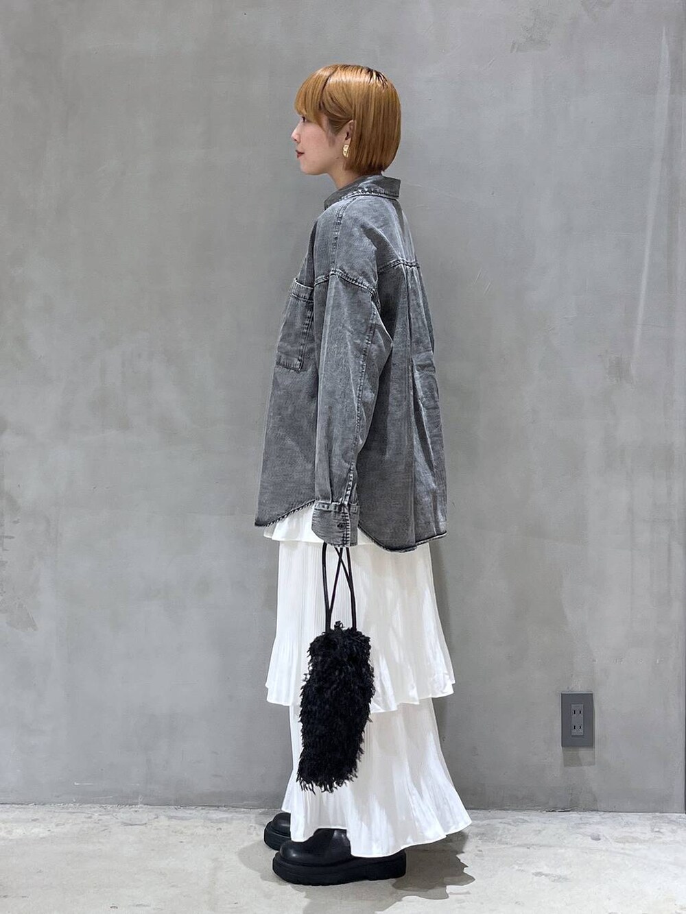 ベージュ系のスカート、ブラック系のショルダーバッグ、ブラック系のシャツ/ブラウスを着用したレディースの秋コーディネートの2枚目の写真