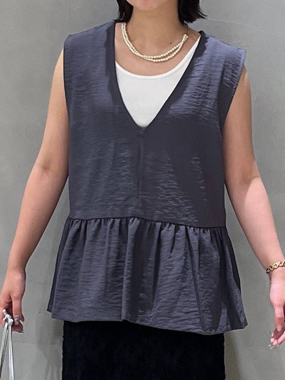 シルバー系のショルダーバッグ、ブラック系のサンダル、ブラック系のスカートを着用したレディースの夏コーディネートの5枚目の写真