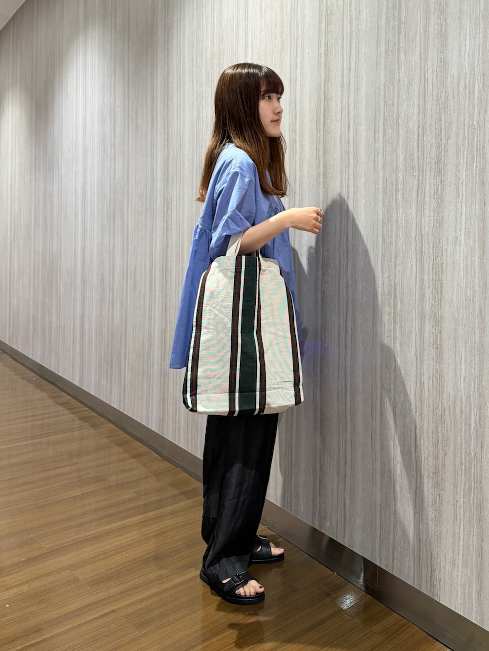 ブルー系のシャツ/ブラウス、ブラック系のデニムパンツ、ブラック系のサンダルを着用したレディースの夏コーディネートの6枚目の写真