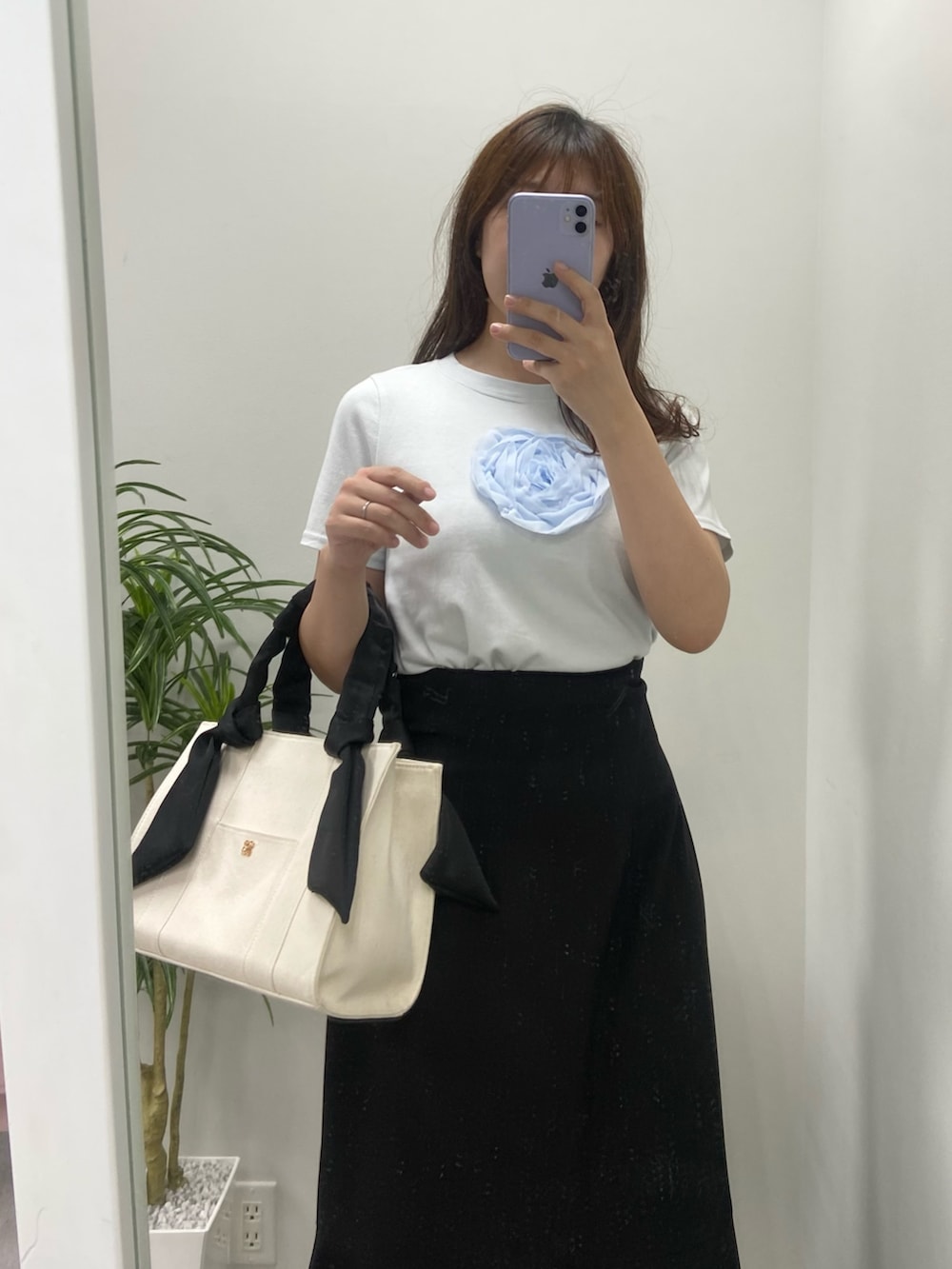 ホワイト系のトートバッグ、シルバー系のサンダル、ブラック系のスカートを着用したレディースの夏コーディネートの6枚目の写真