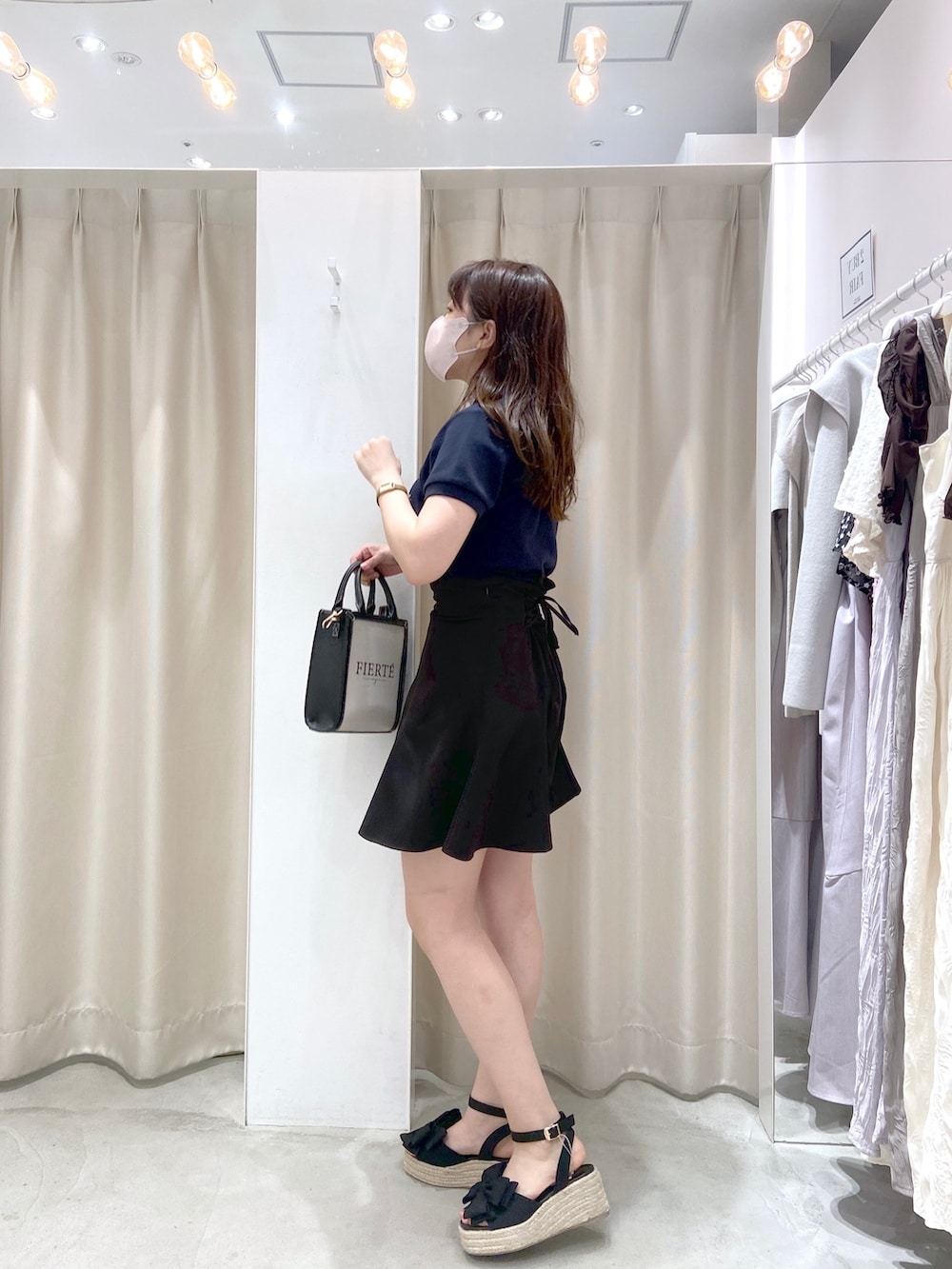 ブルー系のTシャツ/カットソー、ブラック系のスカート、イエロー系のショルダーバッグを着用したレディースの春コーディネートの3枚目の写真